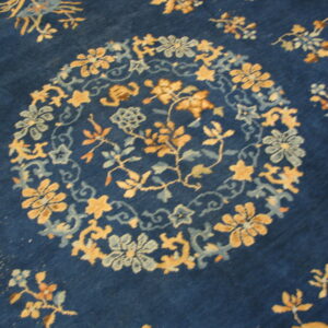 Deep blue rug featuring a large gold and sky blue circular floral medallion motif.