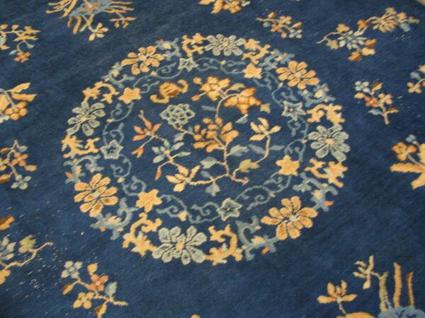 Deep blue rug featuring a large gold and sky blue circular floral medallion motif.