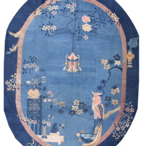 Oval blue rug featuring a scenic border pattern with pink birds, cherry blossoms, and lanterns.