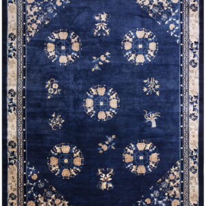 A navy rug featuring scattered beige floral medallions and sprays, bordered by a detailed cream key pattern.