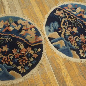 Matching round dark blue rugs featuring a colorful mountainous landscape and floral pattern on wood floor.