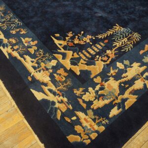 Dark blue rug displaying a detailed beige and coral floral border on rustic wooden floorboards.