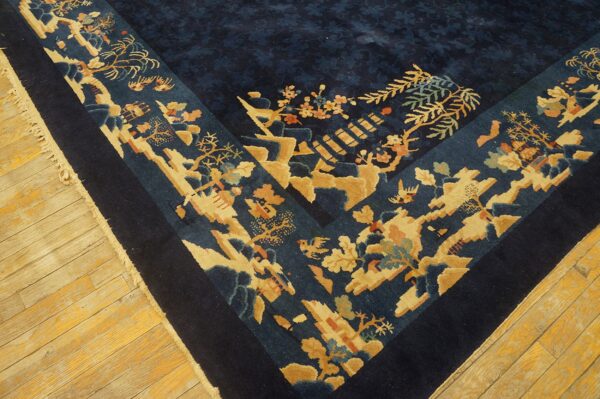 Dark blue rug displaying a detailed beige and coral floral border on rustic wooden floorboards.