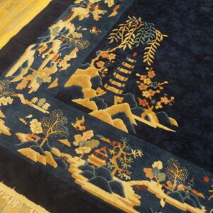 Navy blue high-pile rug with a detailed landscape border rests on light wood plank flooring.