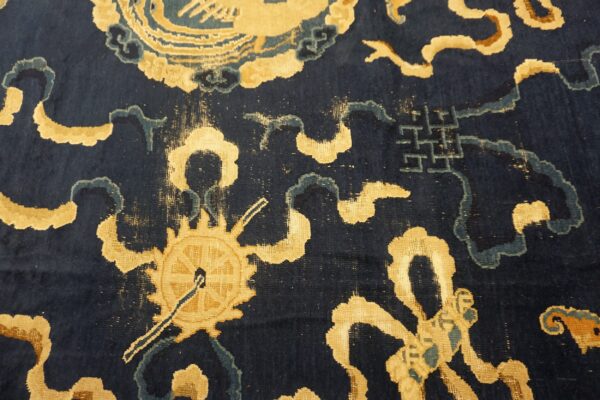 Short pile navy blue rug featuring gold wheel, cloud, and geometric motifs with teal accents.
