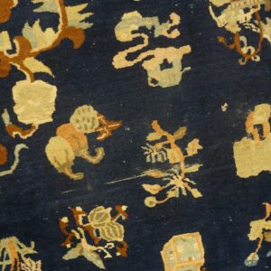 Dark blue rug close-up detailed with stylized shapes in tan, terracotta, and pale blue.