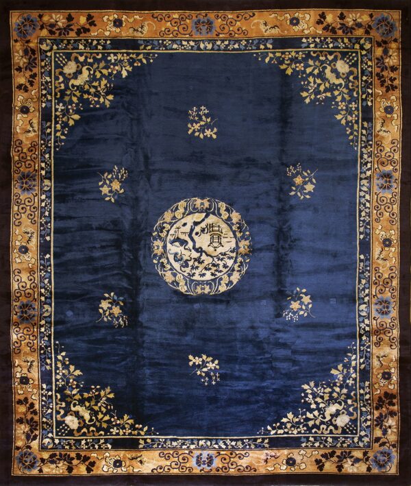 Navy blue rug with a central cream medallion and scattered tan floral designs, framed by an ornate tan border.