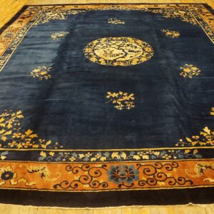 A deep blue rug with a gold central medallion and ornate rust-colored borders on wood planks.