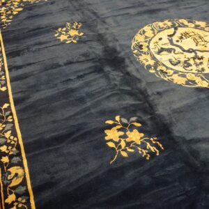 Navy rug featuring gold floral sprays, a large circular medallion, and a wide mustard yellow border.