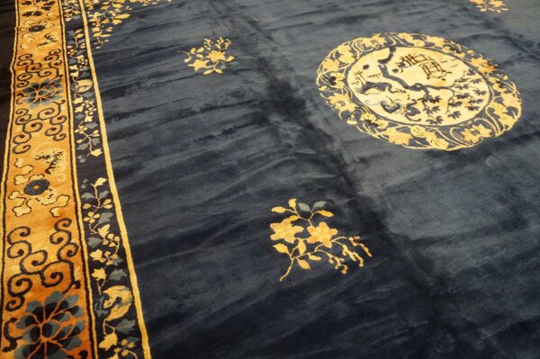 Navy rug featuring gold floral sprays, a large circular medallion, and a wide mustard yellow border.