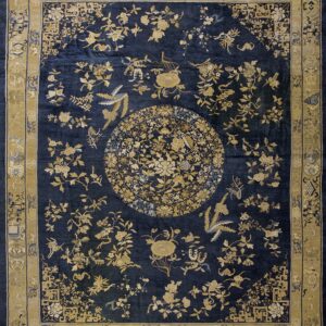 Ornate navy blue rug featuring a large gold floral medallion and a wide patterned border.