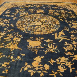 A large navy blue rug featuring golden yellow floral patterns and a central medallion on hardwood floors.