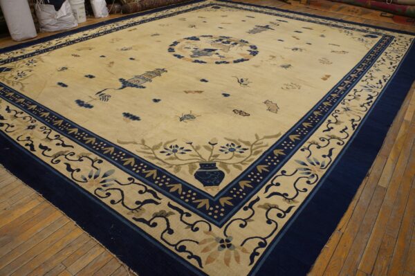 Traditional cream rug with a detailed navy border and scattered blue chinese motifs on hardwood floors.