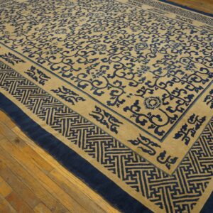 Blue floral pattern covers a beige rug with a wide geometric border, displayed on wooden floors.