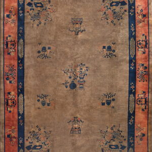 Taupe rug with scattered navy and peach motifs, bordered by dark blue and wide coral panels.