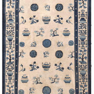 Rectangular rug with a cream field and dark blue pattern showing vases, circular motifs, and flora.