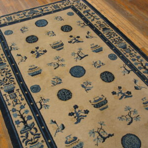 Beige rug featuring scattered blue floral, vase, and medallion patterns on a glossy wood floor.