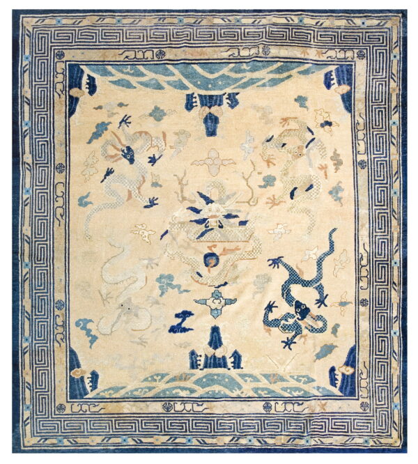 A square rug with a pale yellow field, navy and light blue dragons, and a geometric meander border.