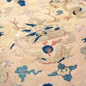 Beige rug detail showing a dragon and cloud pattern in navy blue, teal, and pale pink.