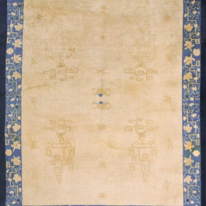 Pale yellow area rug with faint geometric motifs and a wide, stylized blue and cream floral border.