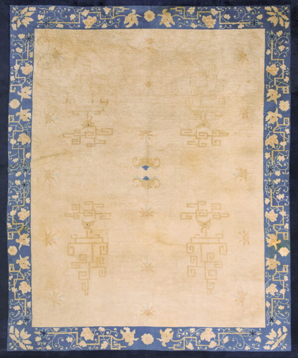 Pale yellow area rug with faint geometric motifs and a wide, stylized blue and cream floral border.