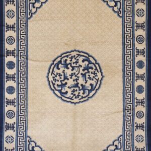 Beige rug featuring a large blue circular medallion framed by detailed geometric borders and symbols.