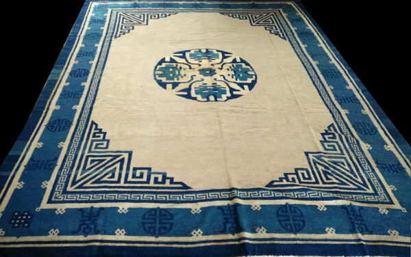 Antique chinese - peking chinese knotted rug 3 Rectangular cream and indigo rug featuring a dense geometric border and large central circular medallion design.