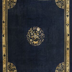 Deep blue rug with an ornate gold border featuring geometric details and a central floral motif.
