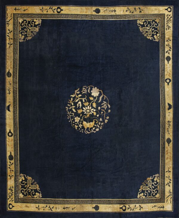 Deep blue rug with an ornate gold border featuring geometric details and a central floral motif.