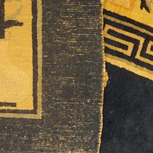 Detail showing flat yellow weaving with dark motifs beside a plush dark rug featuring a yellow Greek key pattern.