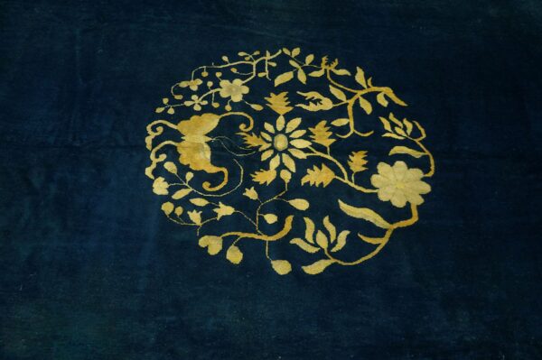 Deep blue rug with a central golden yellow medallion featuring flowing floral motifs.