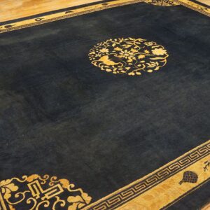 Navy rug with a gold border and central floral medallion displayed on light wooden floorboards.