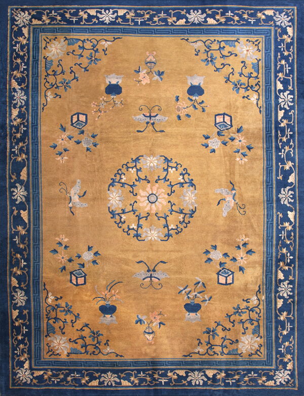 Gold rug with dark blue borders and scattered medallions, vases, butterflies, and flowering branches.