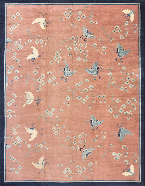 Rose-colored rug with light blue and cream butterflies and white flowers, enclosed by a thick navy border.