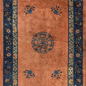 Long runner rug with a soft orange field, a central blue medallion, and detailed navy floral borders.