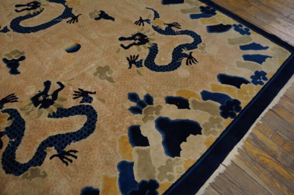 Vintage light coral color chinese cloud band dragon motif peking rug 2 A high-pile rug with blue dragons, yellow, and taupe clouds on a peach background, bordered in navy.