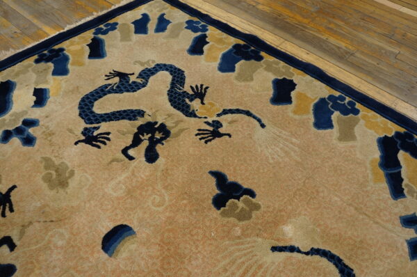 Vintage light coral color chinese cloud band dragon motif peking rug 4 A high-pile rug with a navy dragon and multicolored cloud pattern rests on rustic wood plank flooring.