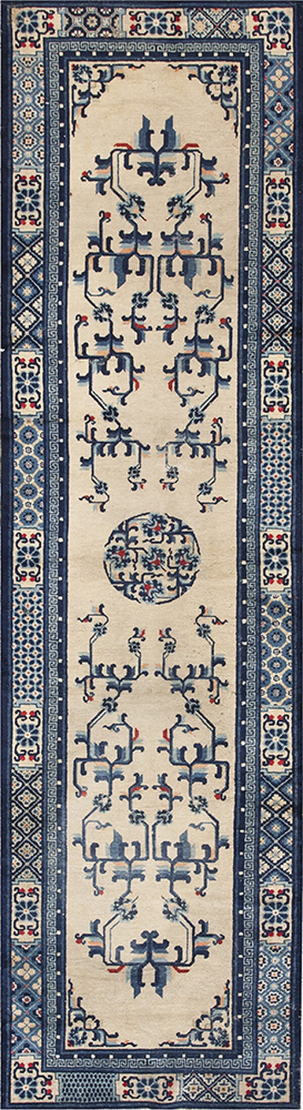 Low pile beige runner rug featuring symmetrical blue stylized motifs and complex patterned side borders.