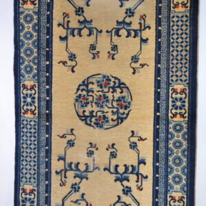 Low pile runner with a tan field, blue and coral designs, and complex geometric borders.
