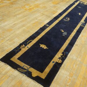 Navy blue Chinese hallway runner with tan border on light hardwood flooring.