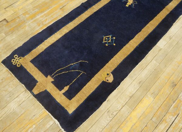 Dark blue wool hallway runner featuring a broad tan border and geometric motifs.