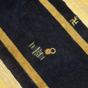 Navy blue Peking runner rug with gold stripes and symbolic motifs on light wood floors.