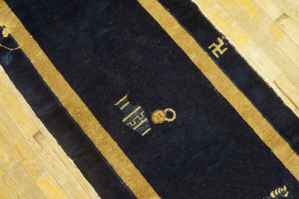 Navy blue peking runner rug with gold stripes and symbolic motifs on light wood floors.
