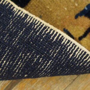 Backing detail of an antique navy and tan Chinese hallway runner rug.