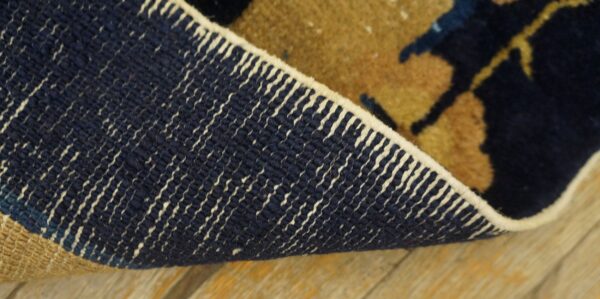 Backing detail of an antique navy and tan chinese hallway runner rug.
