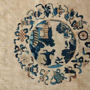 A beige rug showing a round medallion pattern with deep blues, teal, and reddish-brown motifs.