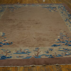 Rectangular taupe rug featuring a wide blue and dark brown scenic border on wood flooring.