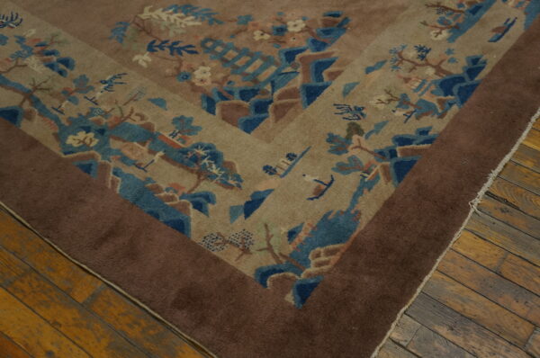 Taupe rug with a pictorial pattern of blue mountains, trees, and birds, bordered in dark brown.