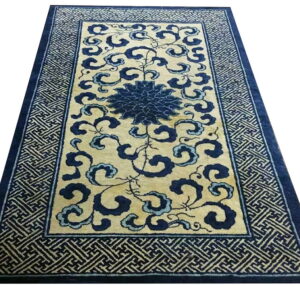 Cream rug with dark blue scrolling floral and cloud patterns and a wide key-pattern border.