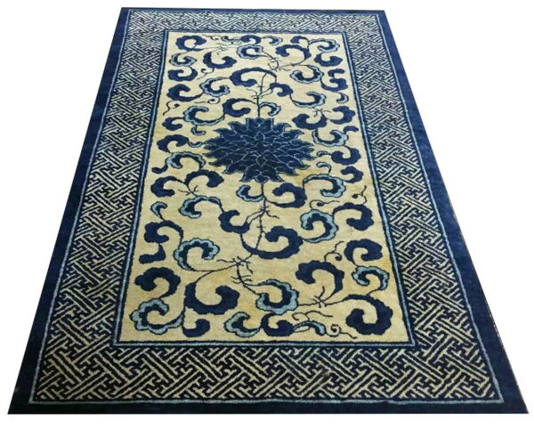 Cream rug with dark blue scrolling floral and cloud patterns and a wide key-pattern border.